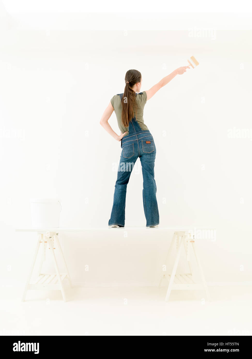 Cheerful dancing woman with painting brush on the table Stock Photo