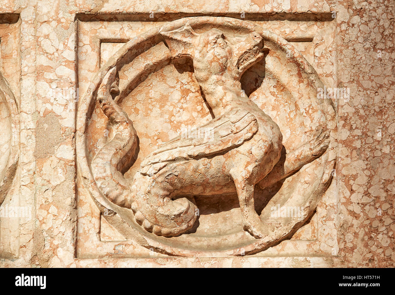 Medieval relief sculptures of mythical dragon on the exterior of the Romanesque Baptistery of Parma, circa 1196, (Battistero di Parma), Italy Stock Photo