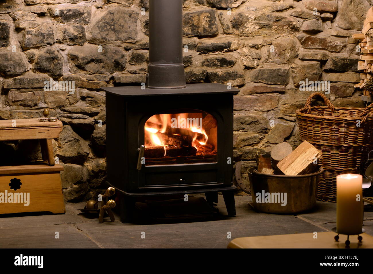 Roaring fire in wood burning stove in fireplace with logs and tongs