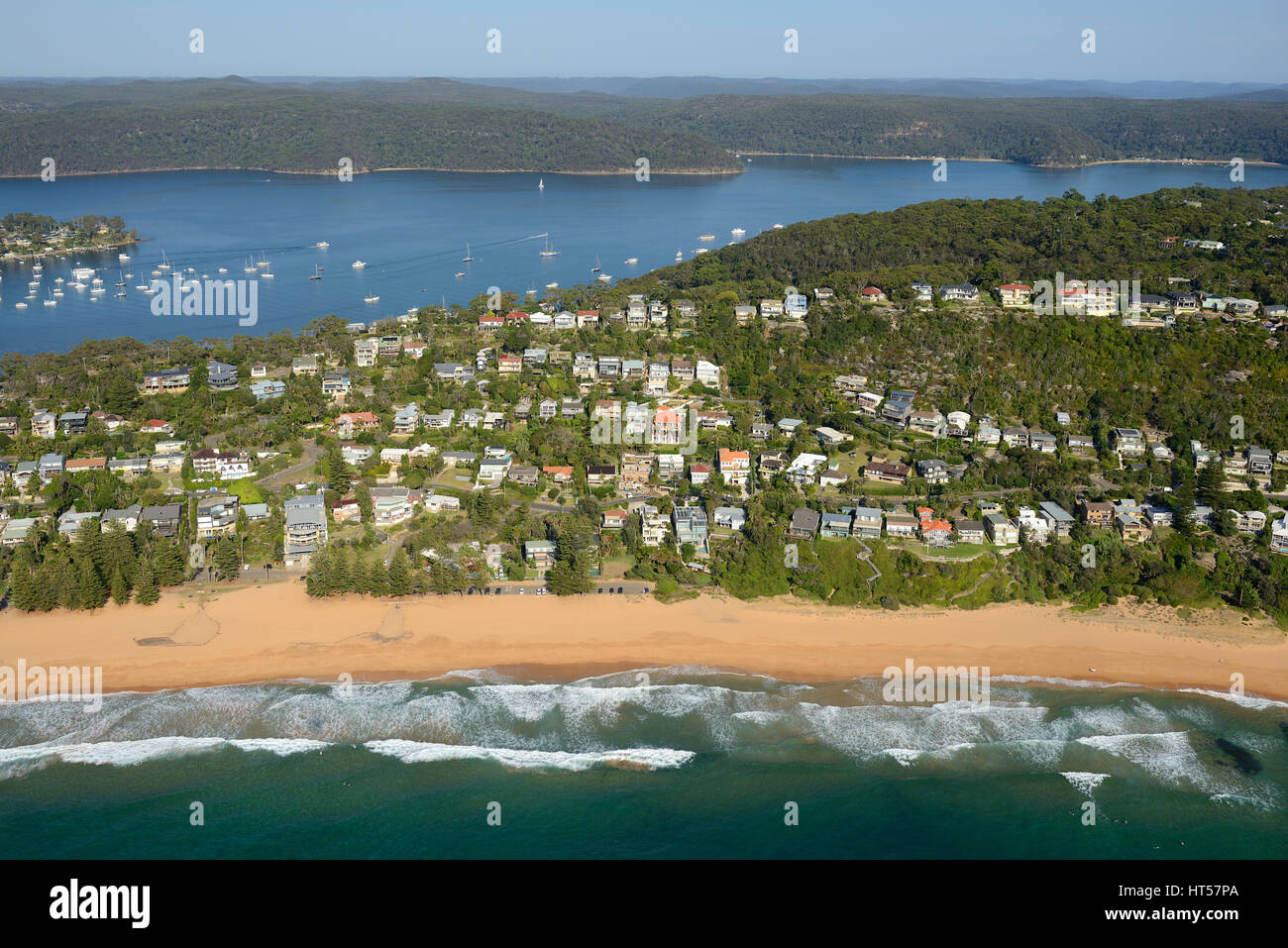 AERIAL VIEW. Residential neighborhood facing the Pacific Ocean with the Pittwater in the distance. Whale Beach, Sydney, New South Wales, Australia. Stock Photo