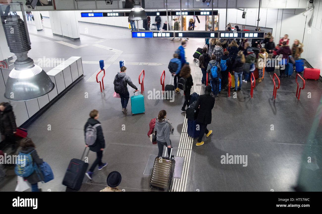 Travellers walk through train station carrying suitcases, Vienna