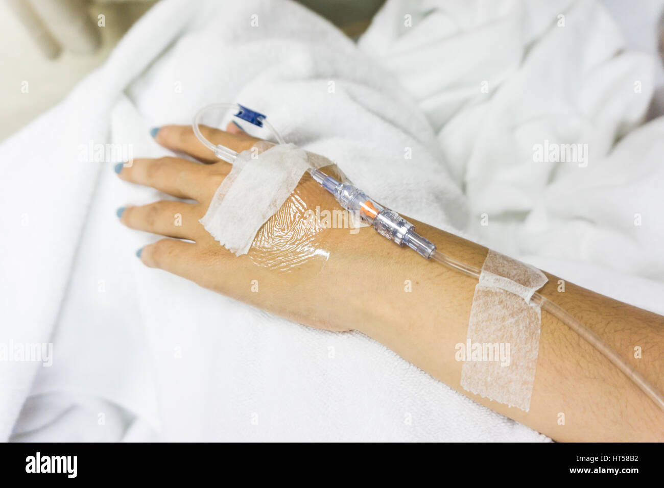 Closeup of hands with intravenous tube to patient's hand in hospital