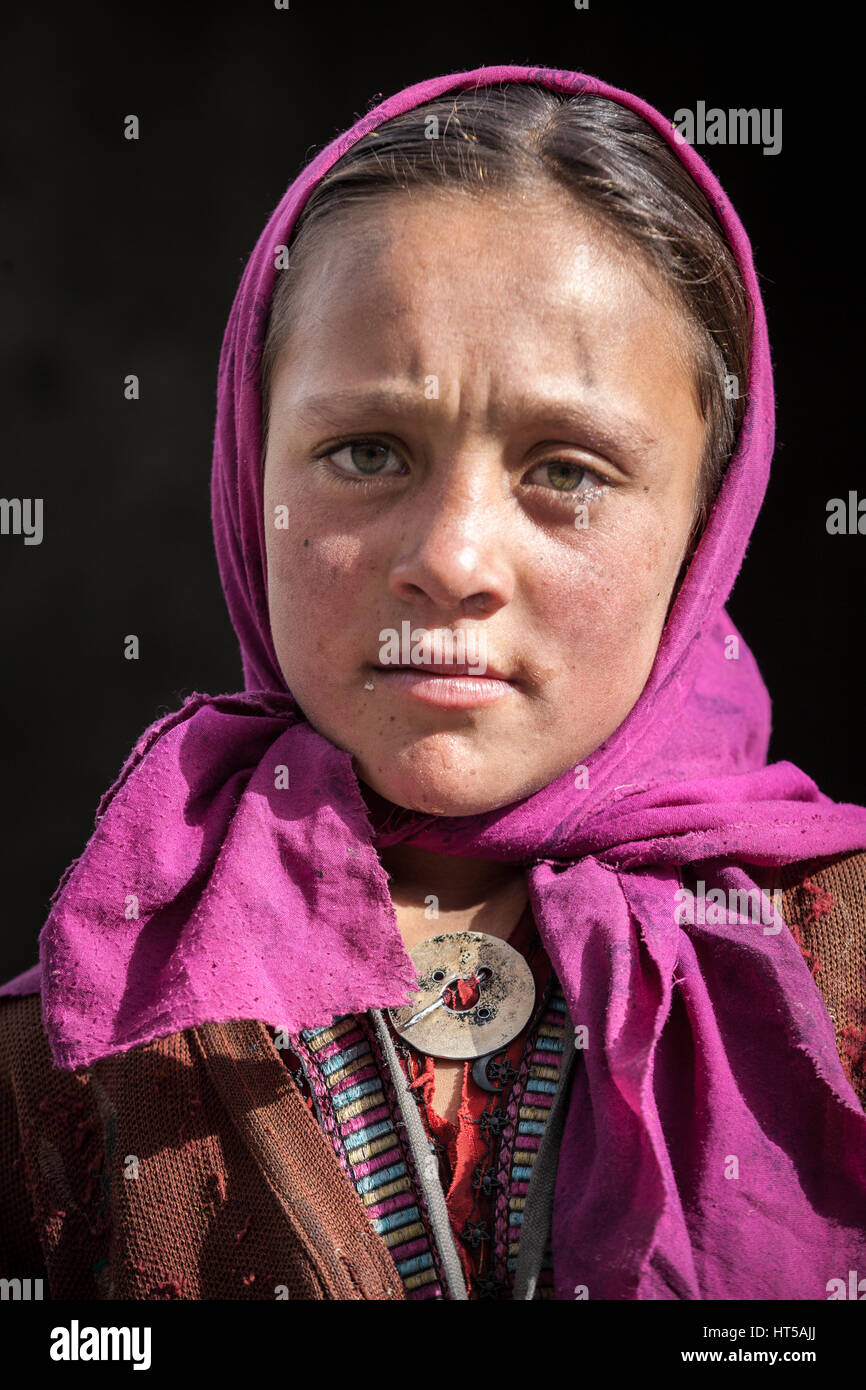 Afghanistan, Wakhan corridor, a portrait of a young girl with violet veil and blue eyes. Stock Photo