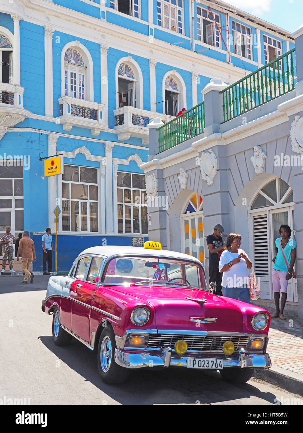 Restored American 1956 Chevrolet being used as a privately owned taxi with colonial architecture in Cespedes Parque Santiago de Cuba. Stock Photo