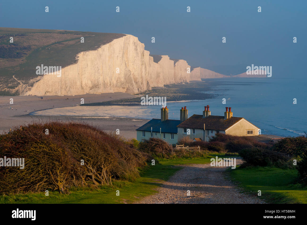 The coastguard cottages at Seaford Head with the seven sisters chalk cliffs in background. Stock Photo