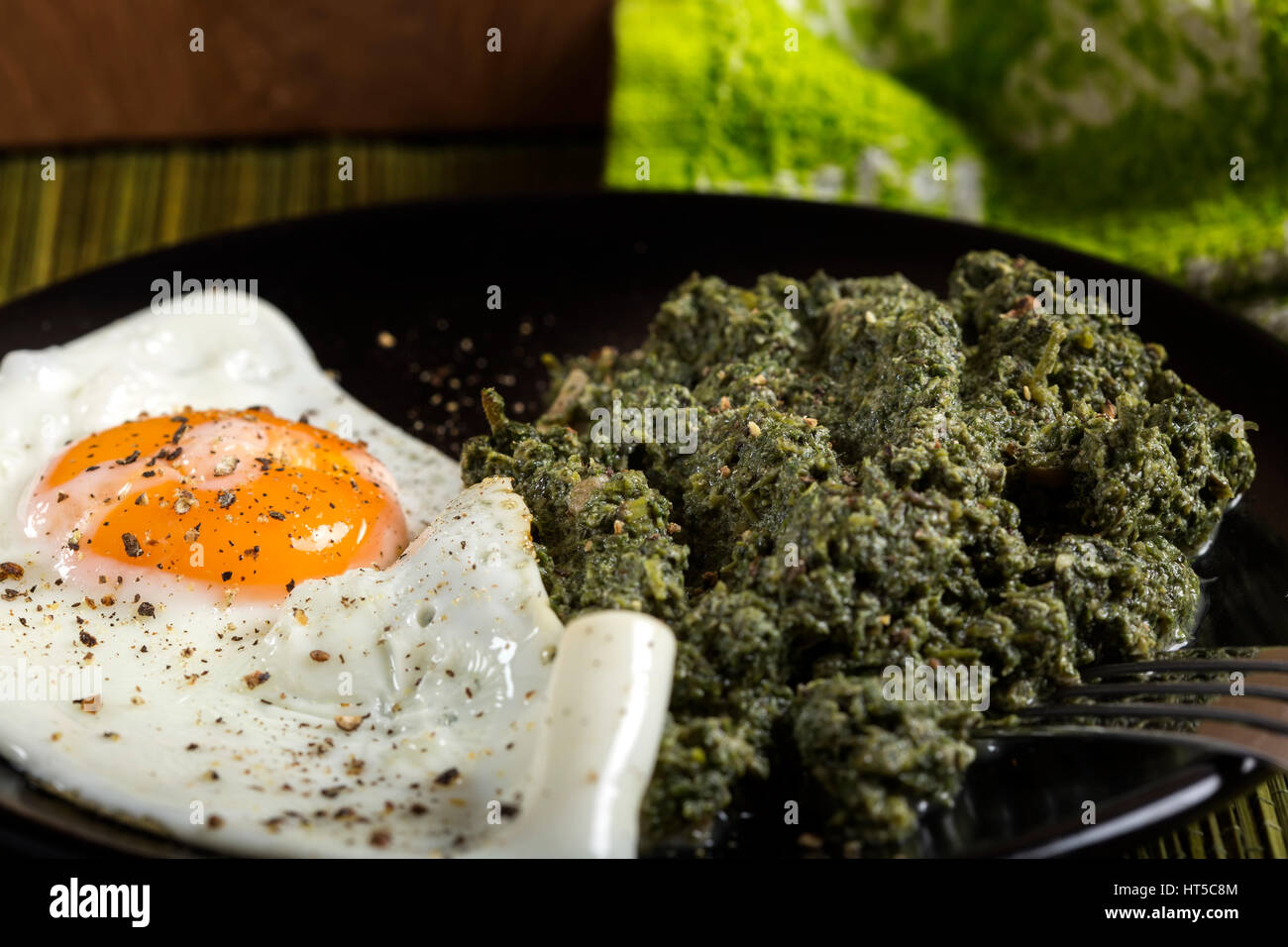 Close up of plate with nettle stew and egg with spices Stock Photo