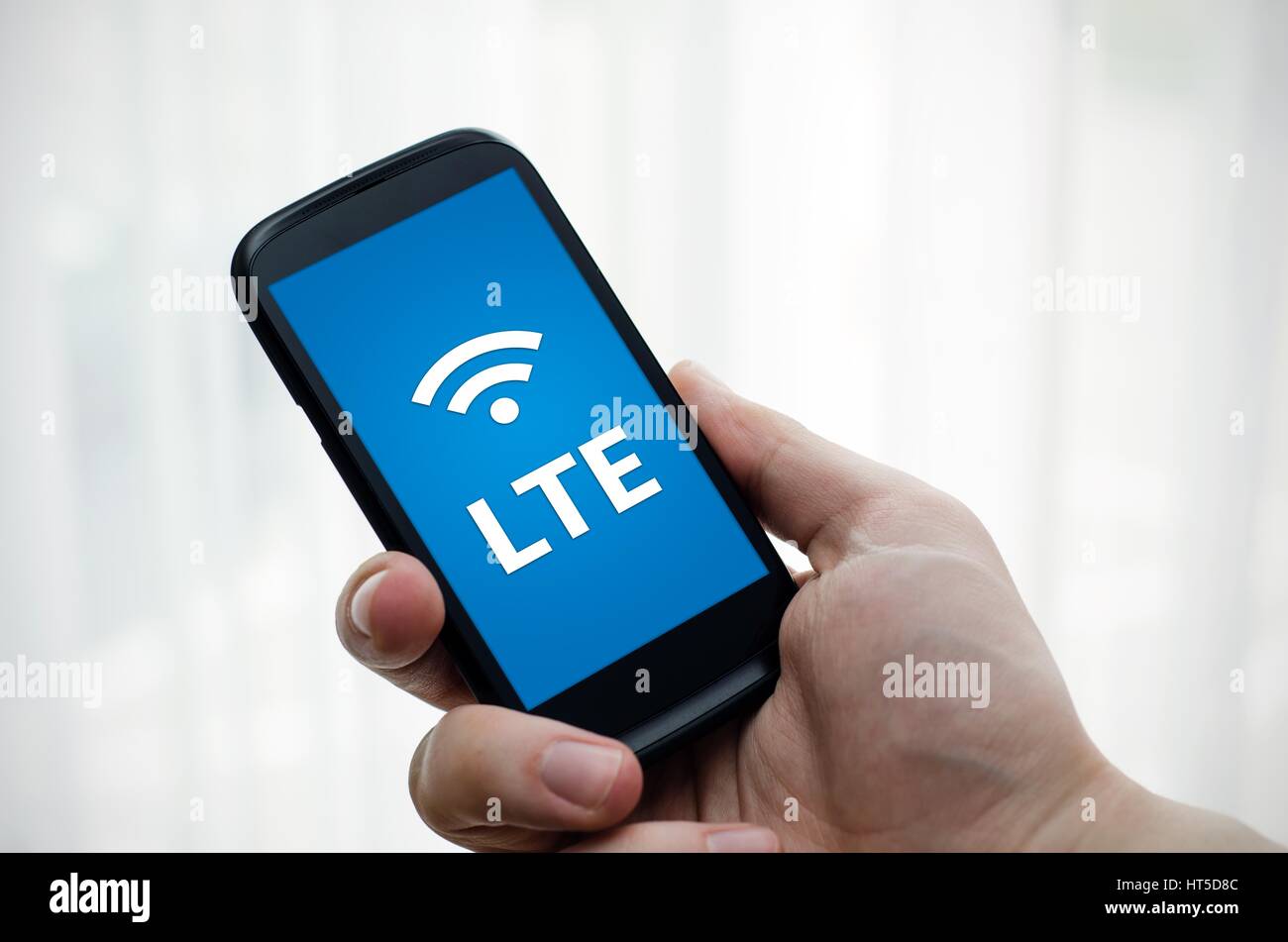 Hand holding mobile phone with LTE fast internet technology Stock Photo