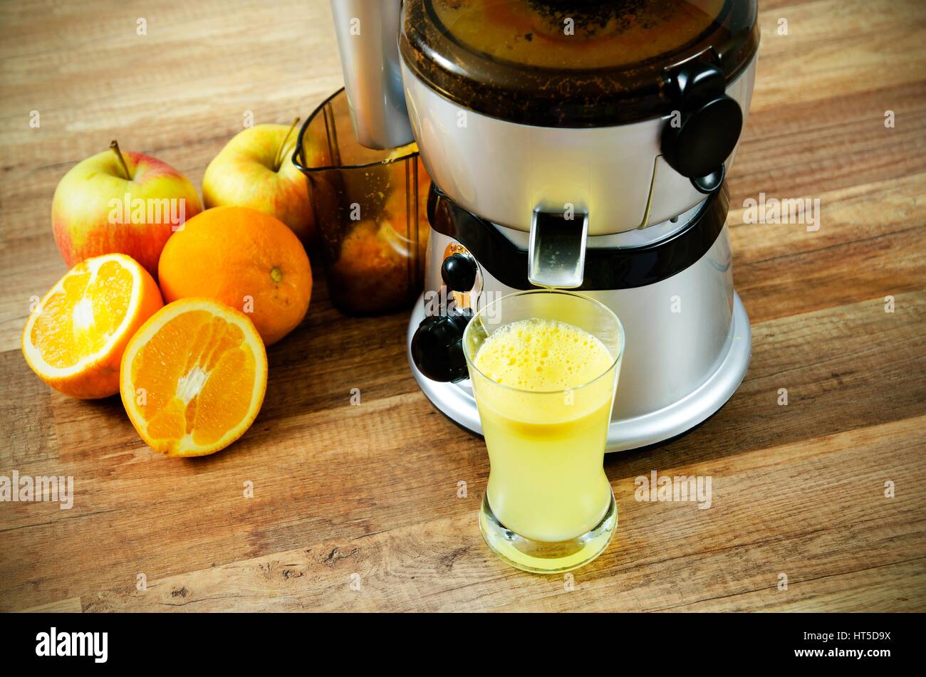 Juicer and orange juice on wooden background Stock Photo Alamy