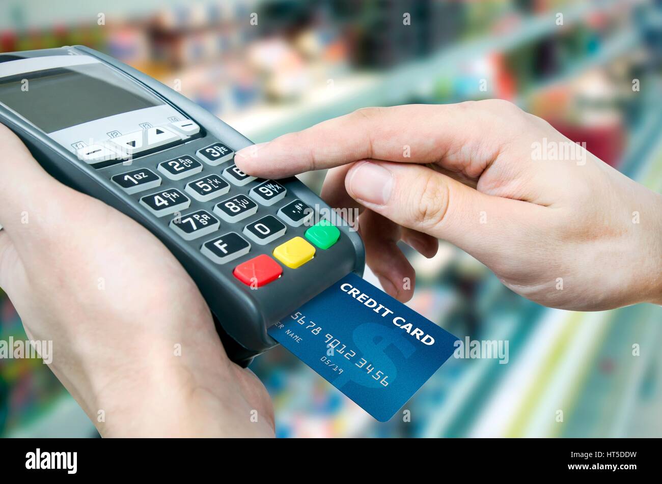 Hand with credit card swipe through terminal for sale in supermarket