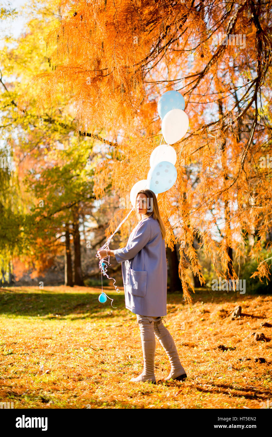 Young pregnant woman walks in autumn park with balloons in hand Stock ...