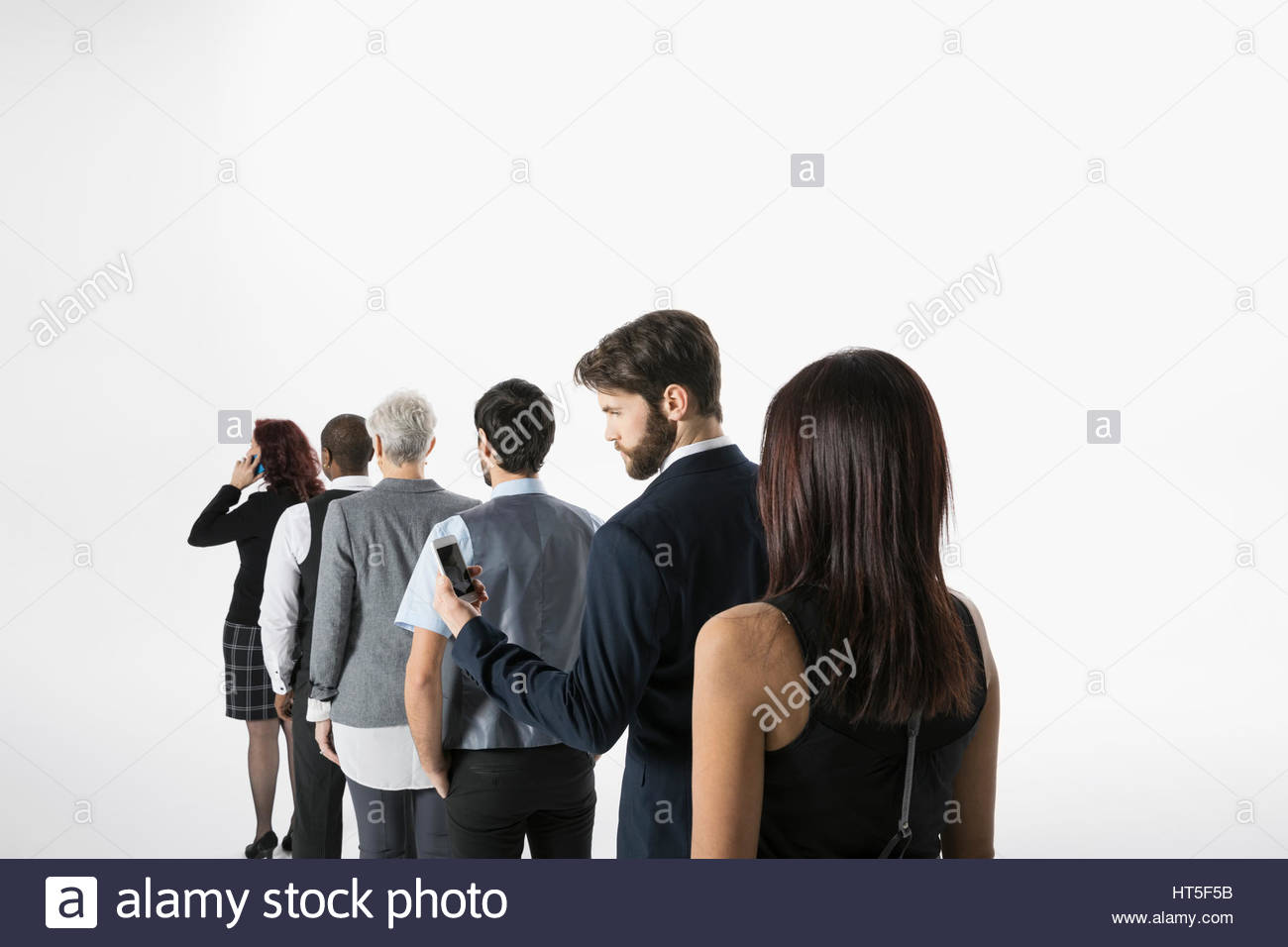Businessman using with cell phone, waiting in queue against white