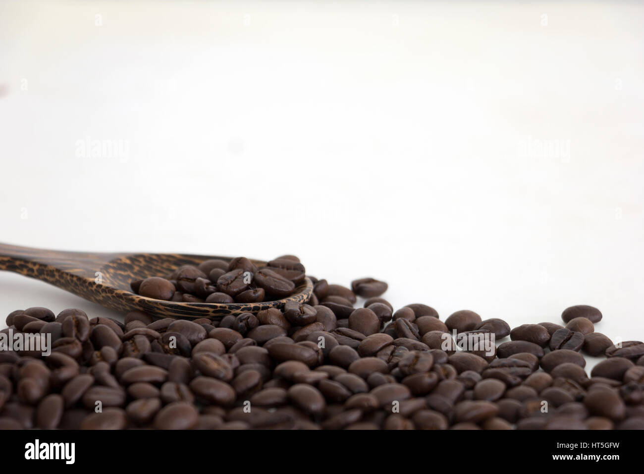 Roasted coffee beans and a wooden spoon on white background Stock Photo ...