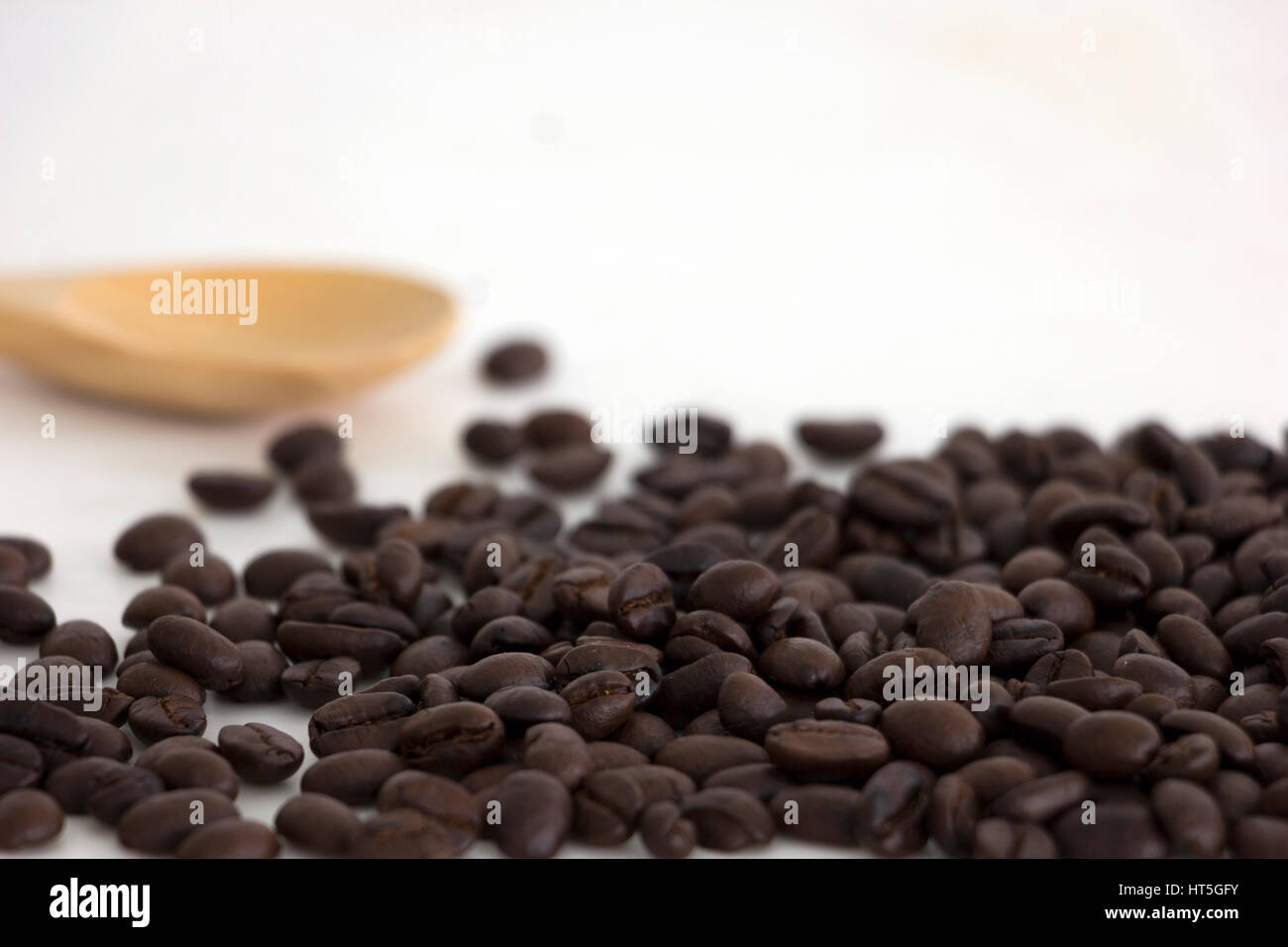 Roasted coffee beans and a wooden spoon on white background Stock Photo ...