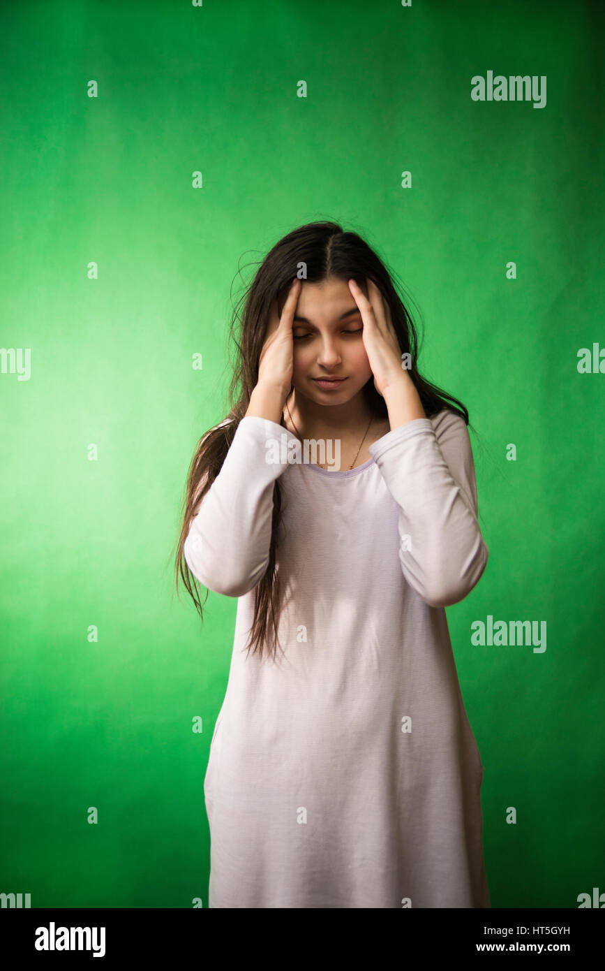 girl in her nightie wants to sleep and rubs his eyes on a green background isolated chroma key Stock Photo