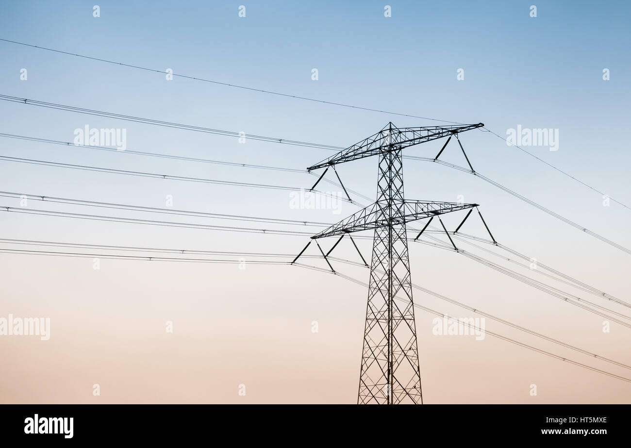 Transmission power tower, electricity pylon over sky background. Steel lattice tower, used to support an overhead power line Stock Photo