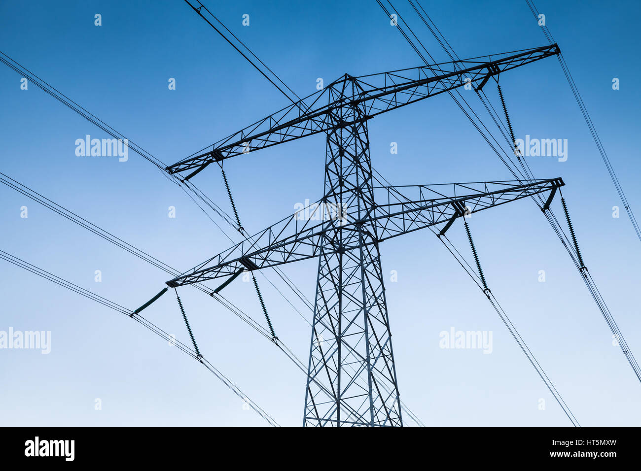Transmission power tower, electricity pylon over blue sky. Steel lattice tower, used to support an overhead power line Stock Photo