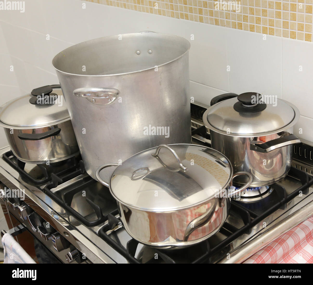 many large steel pans on the stove of the large industrial kitchen of the restaurant Stock Photo