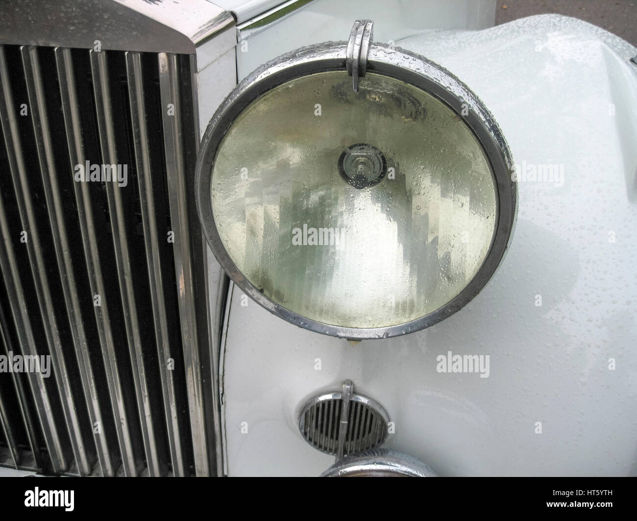 The headlight and part of the grille of a vintage 1954 Rolls Royce motorcar. Stock Photo