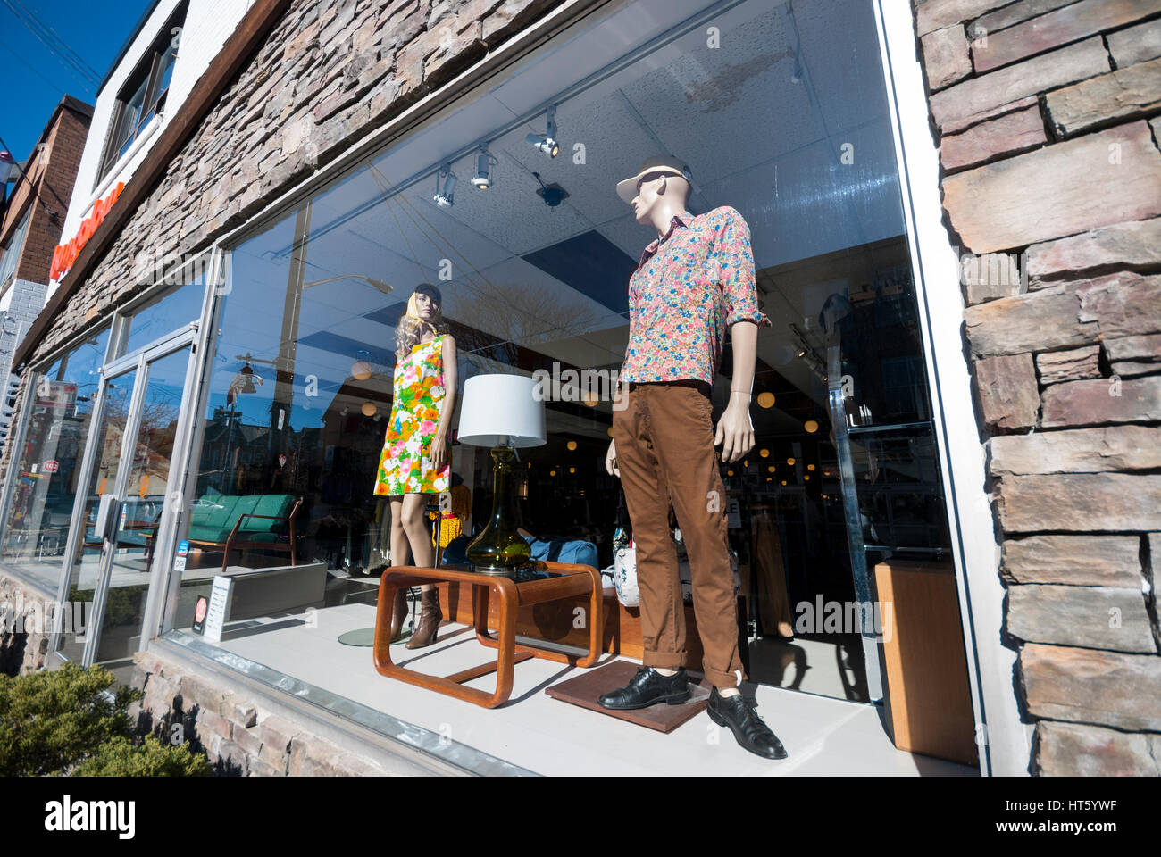 Two mannequins dressed in vintage clothing pose in a shop window in the tourist and shopping district of Kensington Market, Toronto Ontario Canada Stock Photo