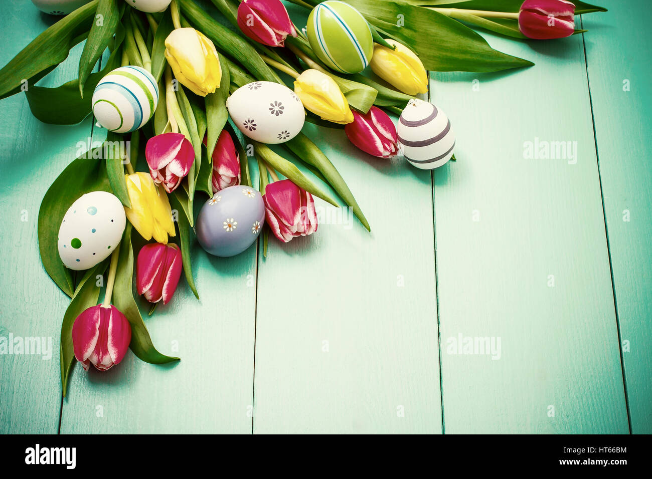 Red and yellow tulips with colorful Easter eggs, top view Stock Photo ...