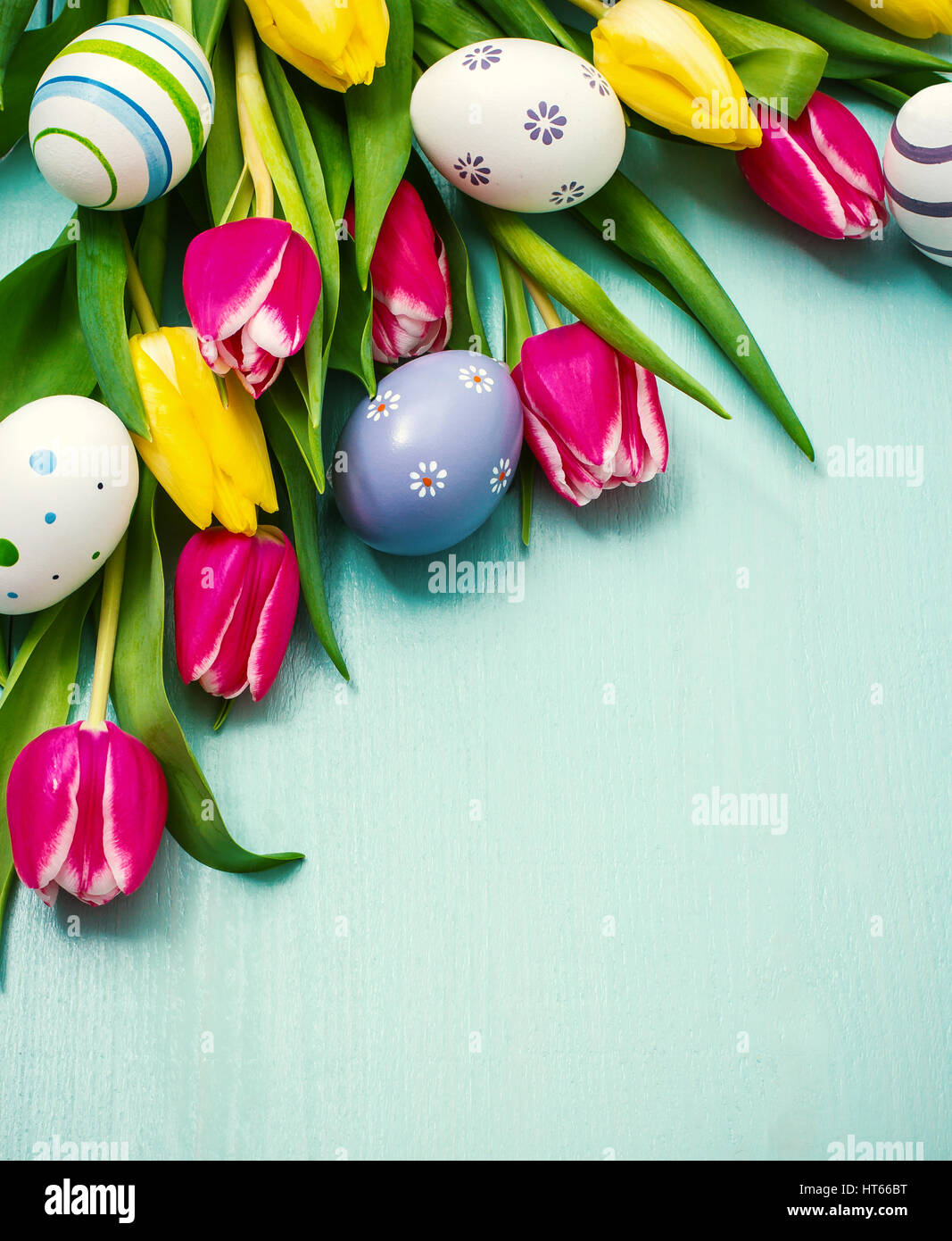 Red and yellow tulips with colorful Easter eggs Stock Photo - Alamy