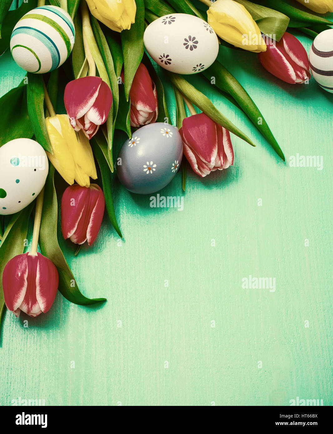 Red and yellow tulips with colorful Easter eggs Stock Photo - Alamy