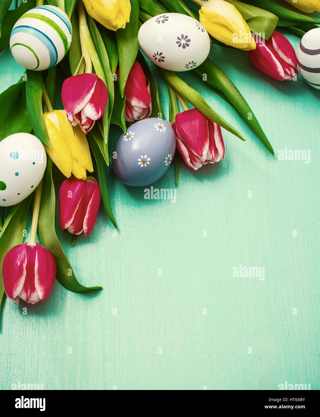 Red and yellow tulips with colorful Easter eggs Stock Photo - Alamy