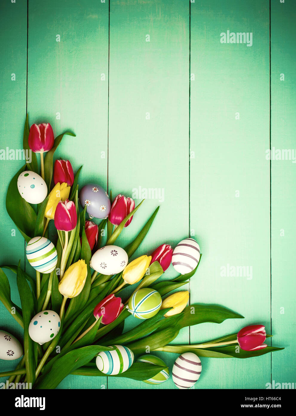 Red and yellow tulips with colorful Easter eggs, top view Stock Photo ...