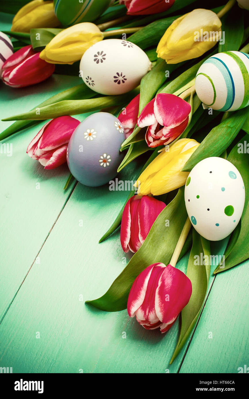 Red and yellow tulips with colorful Easter eggs Stock Photo - Alamy