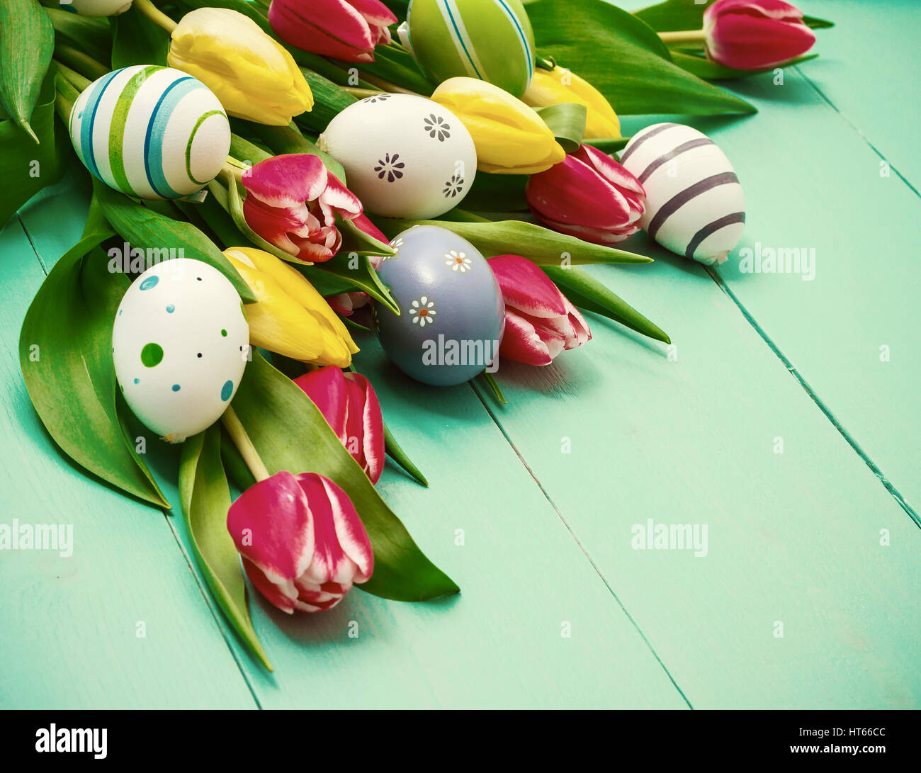Red and yellow tulips with colorful Easter eggs Stock Photo - Alamy