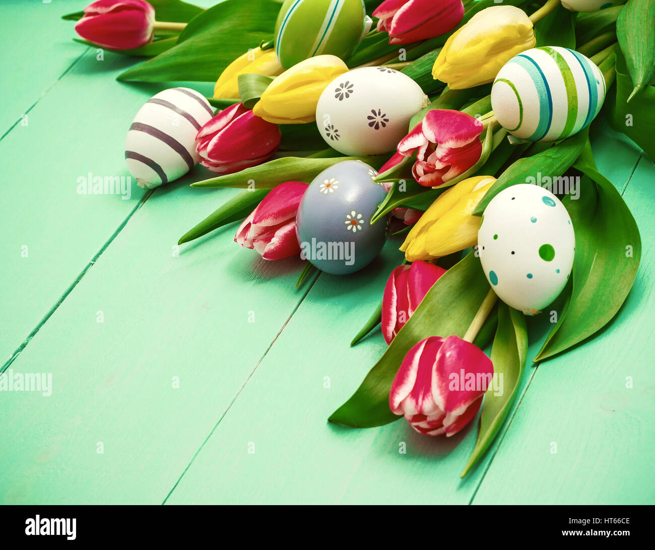 Red and yellow tulips with colorful Easter eggs Stock Photo - Alamy