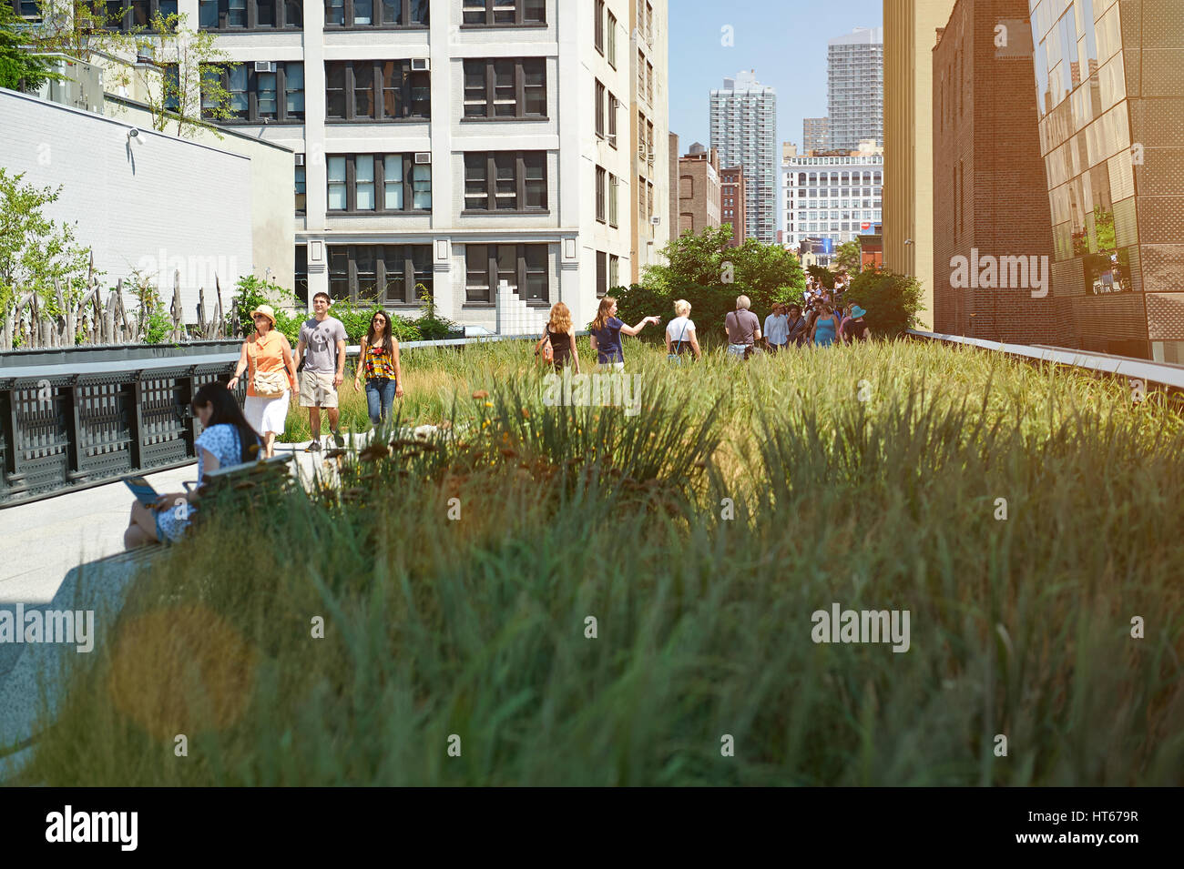 New York, Nicaragua - August 12, 2012: Green grass park in New York city. People walking on urban park on sunny day. Old metro road Stock Photo