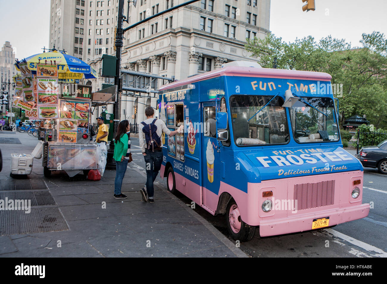 One truck is selling ice cream and the other is selling fast food somewhere in New York, United States of America. Stock Photo