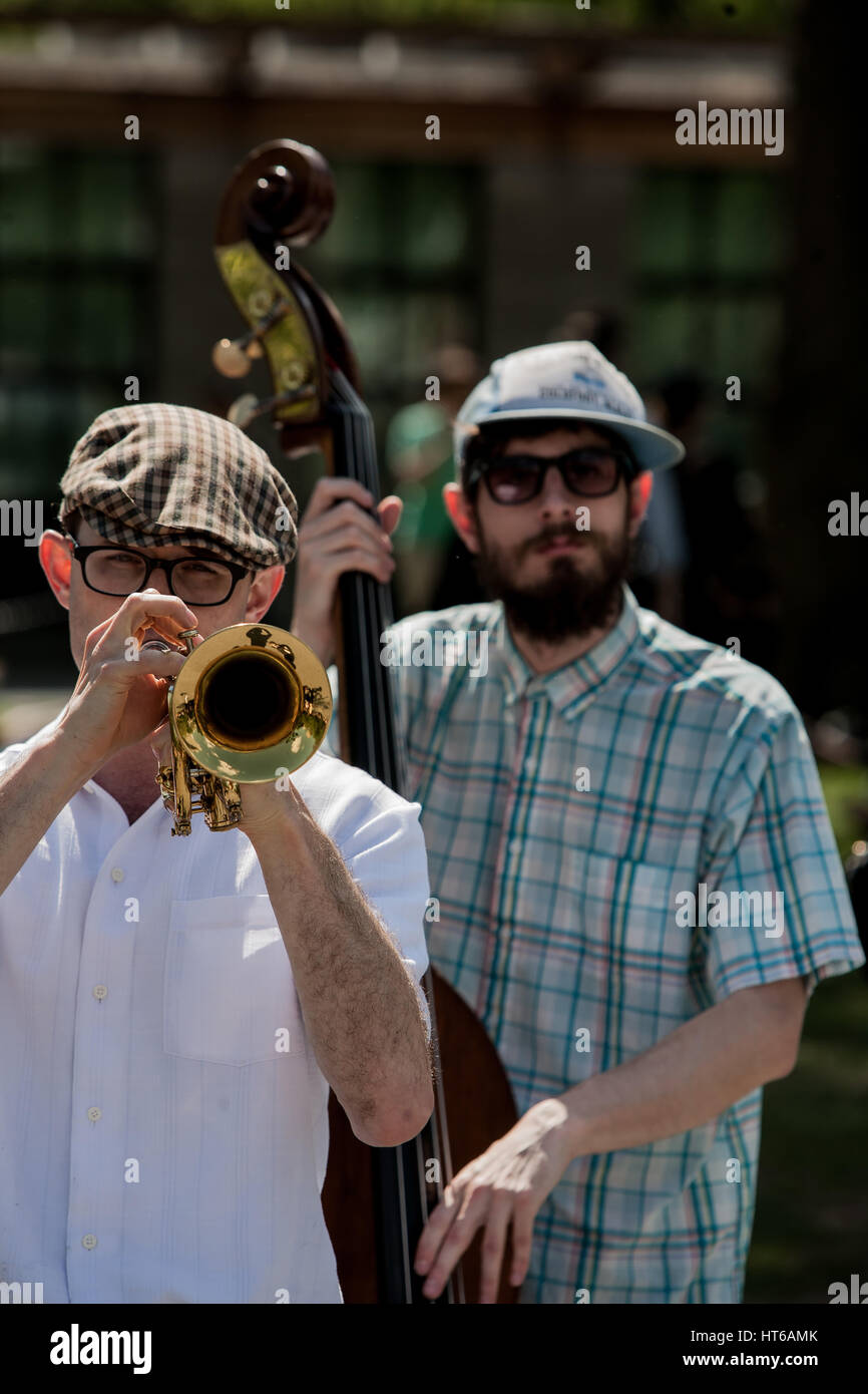 Two street musicians are performing in the middle of a pedestrian zone