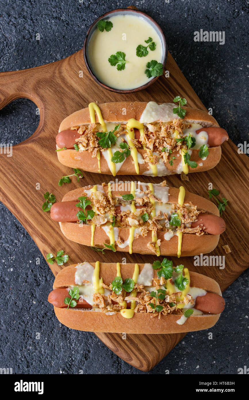Hot dogs with sausage, fried onion, coriander leaves, cheese sauce and