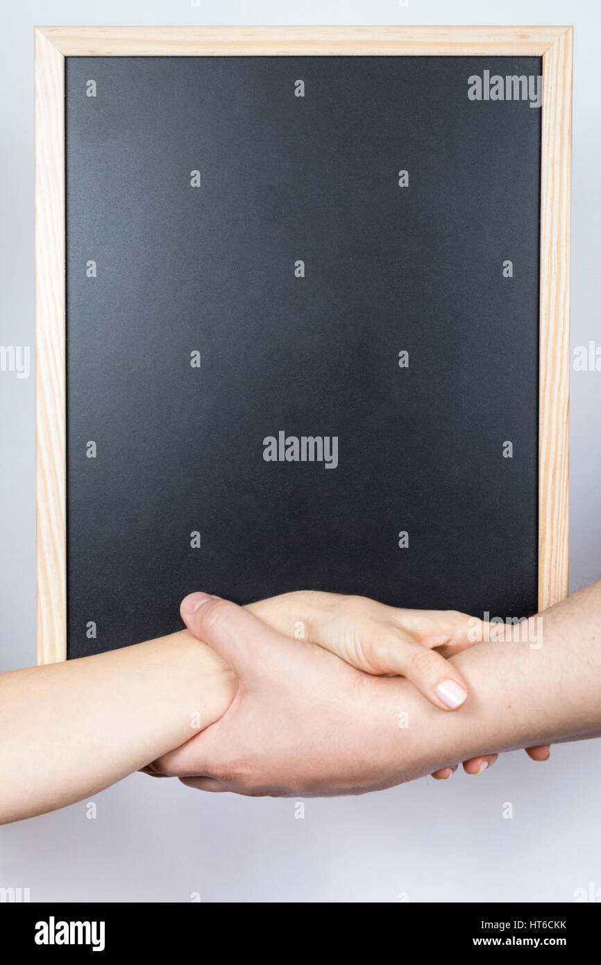 Hands of man and woman holding together an empty whiteboard Stock Photo