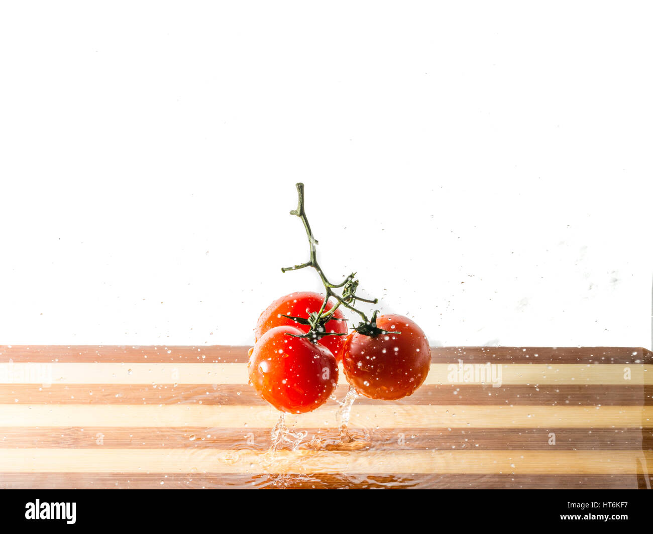 Tomato splash on cutting board with white background Stock Photo - Alamy