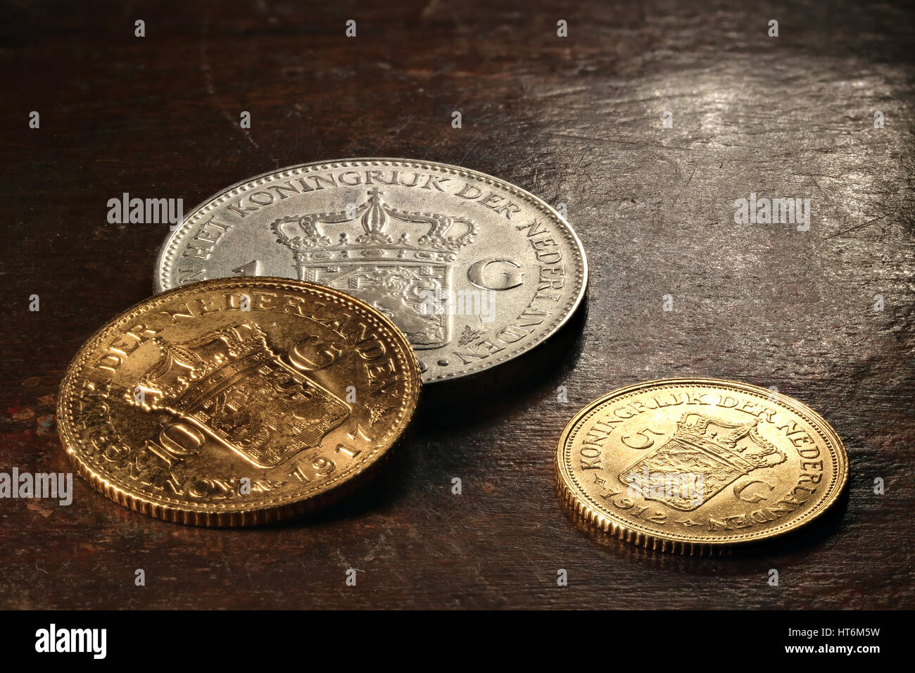 Dutch silver and gold coins on rustic wooden background Stock Photo
