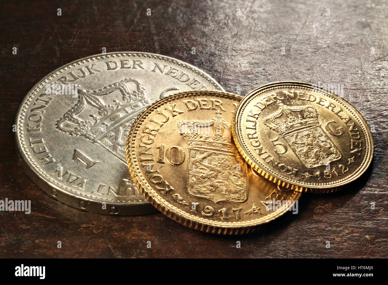 Dutch silver and gold coins on rustic wooden background Stock Photo