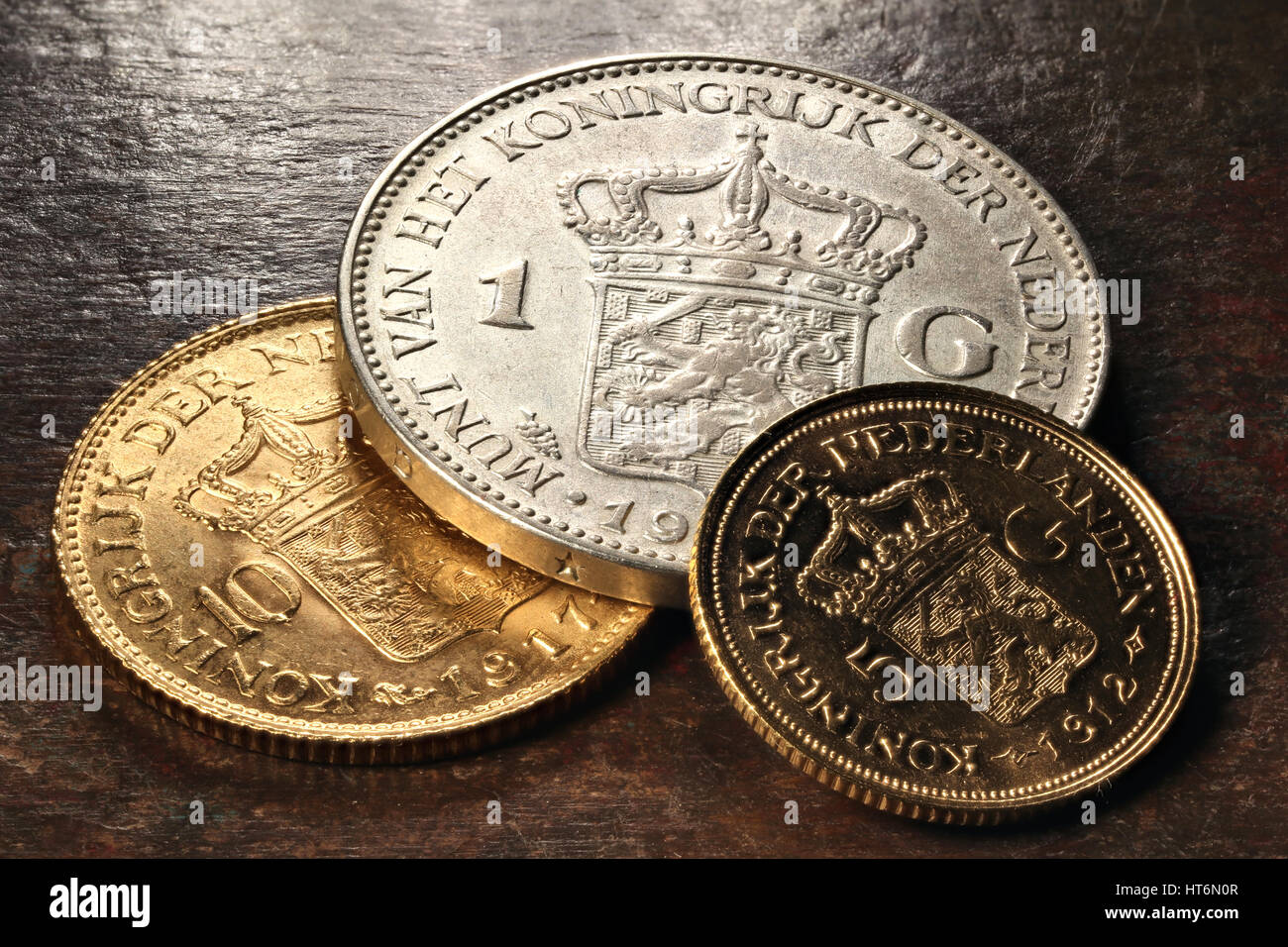 Dutch silver and gold coins on rustic wooden background Stock Photo