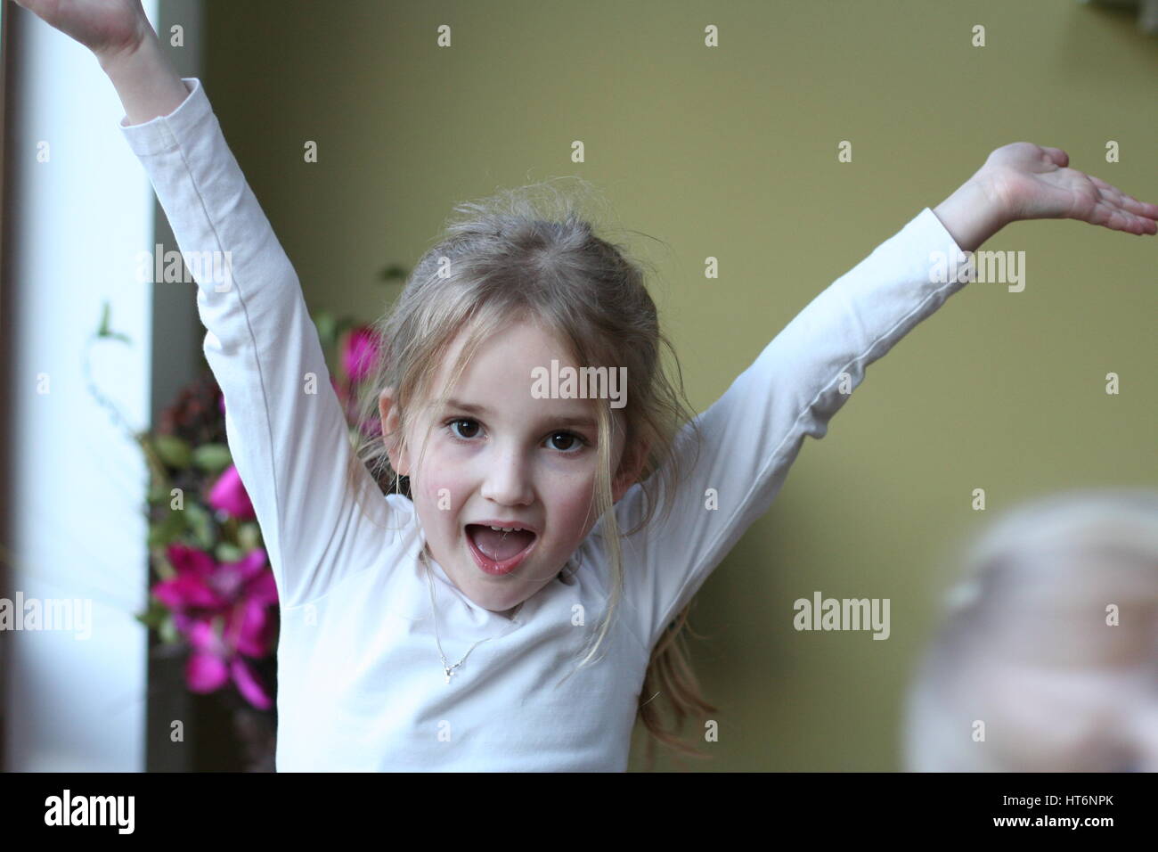 Girl with her arms in the air looking happy Stock Photo