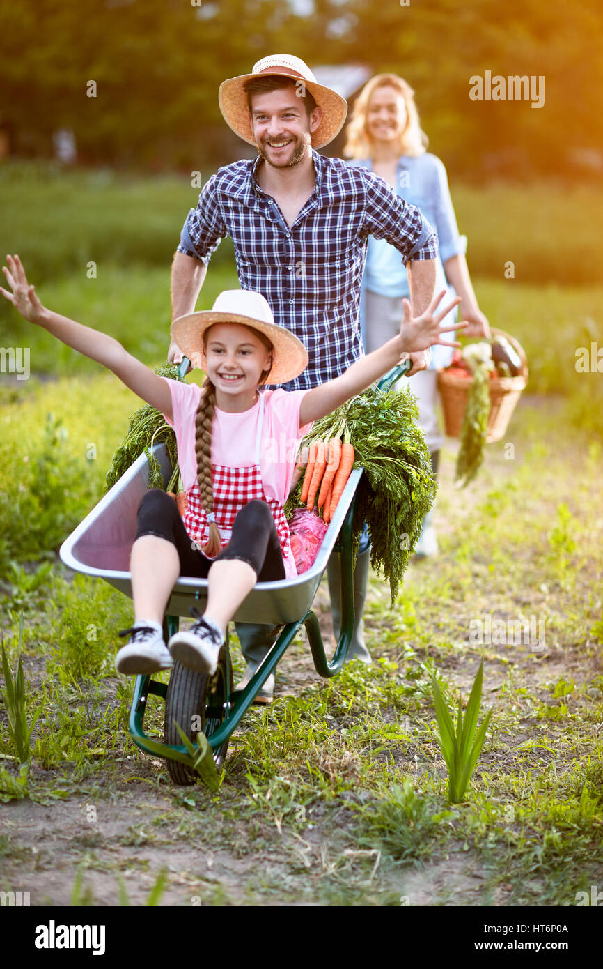 Very cheerful daughter in wheelbarrow with father Stock Photo