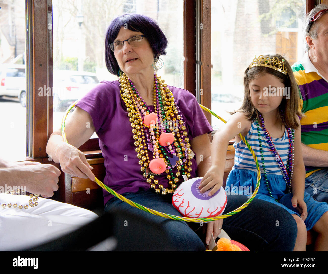 Grand mother and grand daughter ride the streetcar home after the parades on Mardi Gras day.  New Orleans, LA. Stock Photo