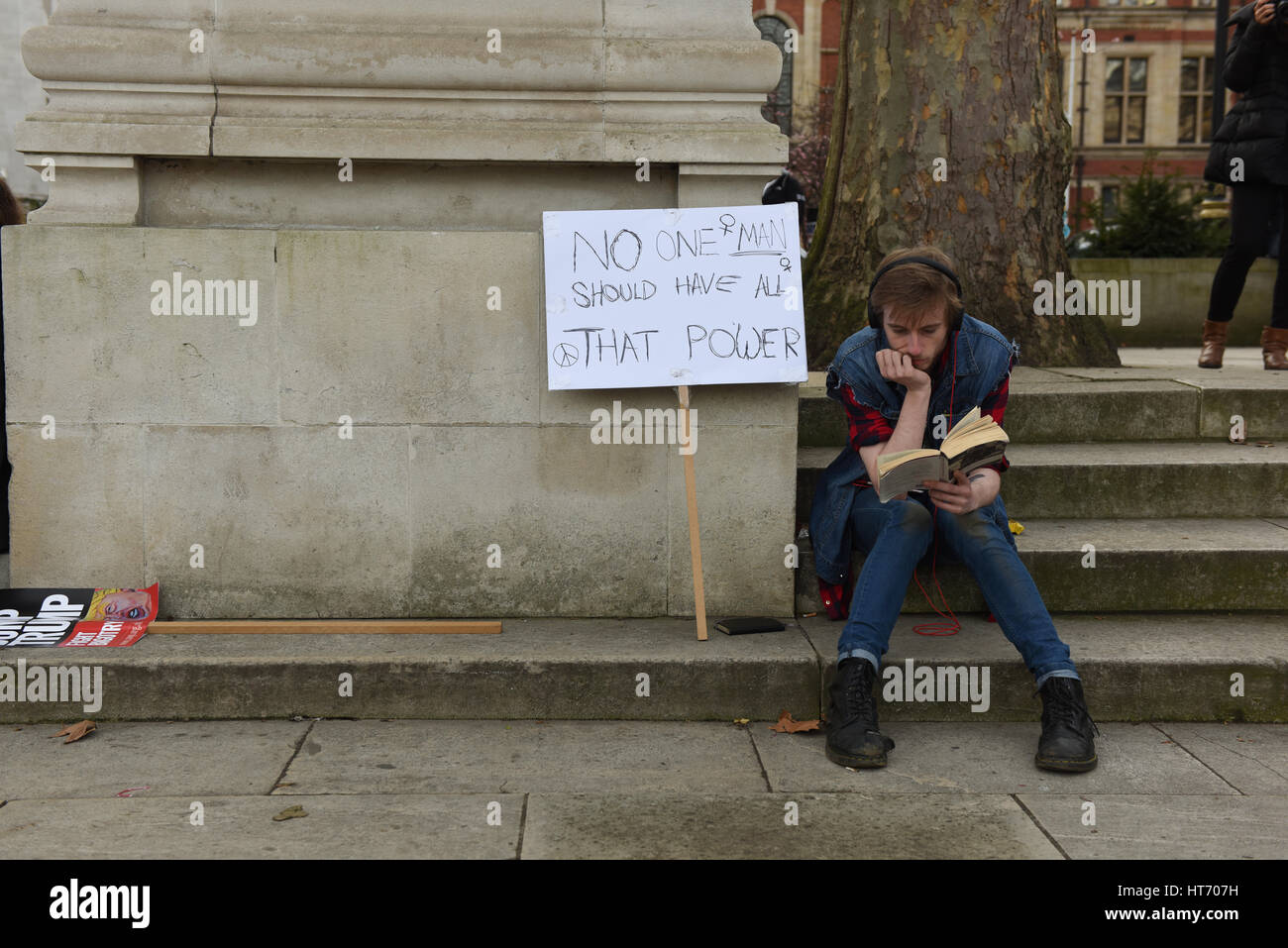 Protester is reading a book during the Stop Trump & Stop Brexit demonstration in Parliament Square, London. Stock Photo