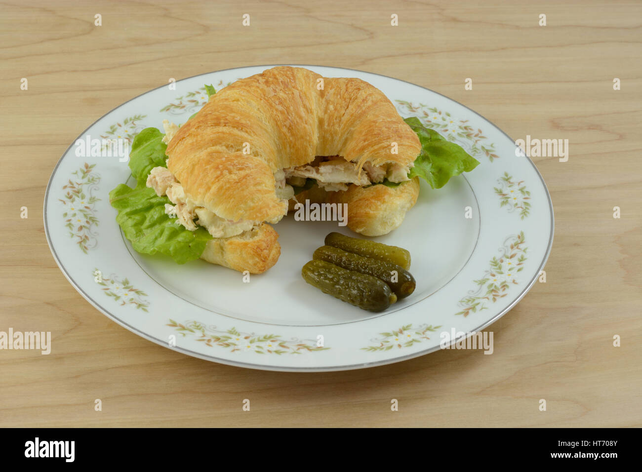 Tuna salad croissant sandwich with sweet pickles on plate Stock Photo