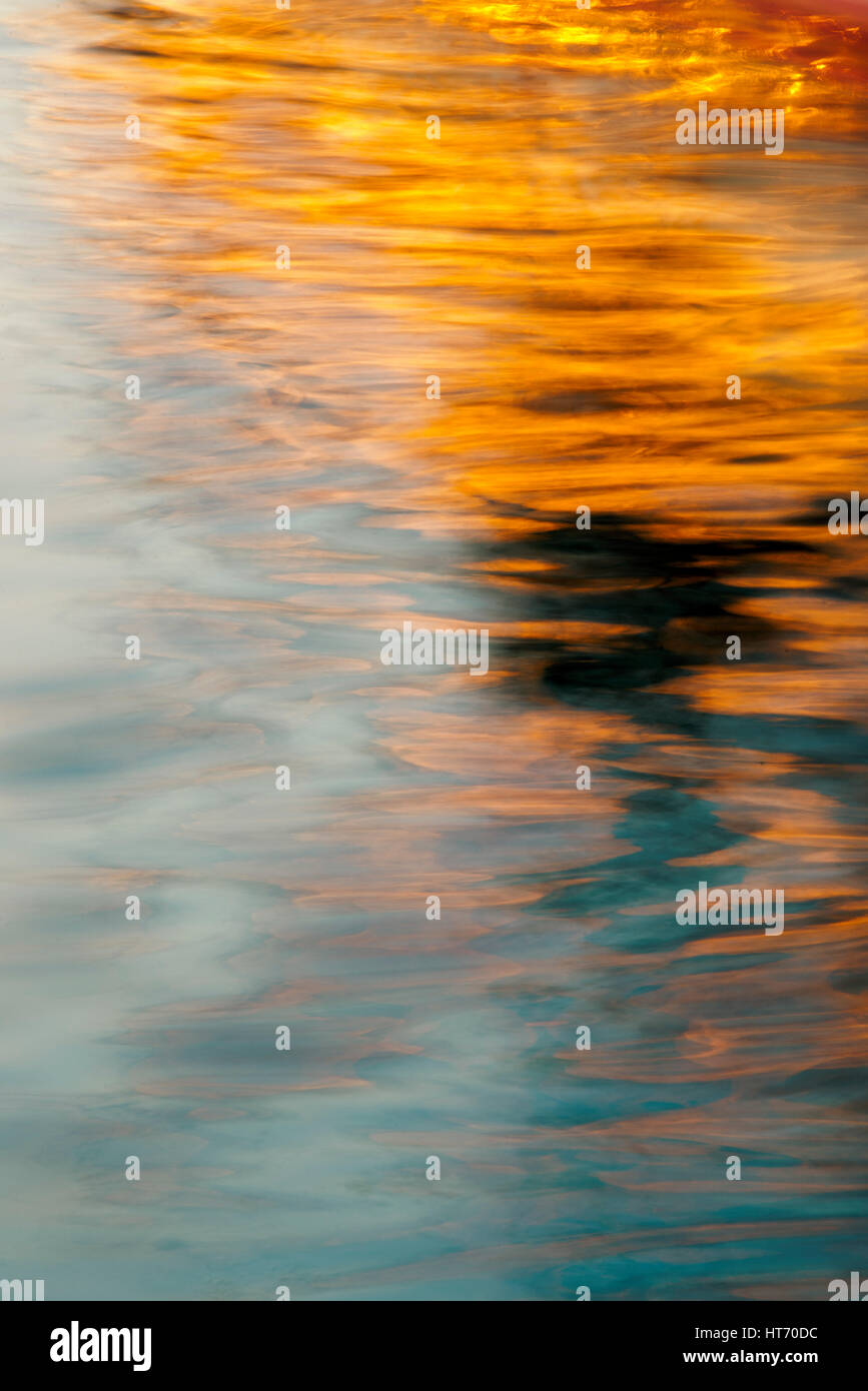 Abstract golden colored waves on sea surface at sunset. Long exposure Stock Photo