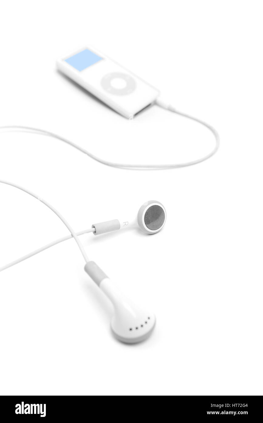 Bath, United Kingdom - March 11, 2011: Studio shot of white earbuds with an Apple iPod Nano out of focus in the background. Shot against a plain white Stock Photo