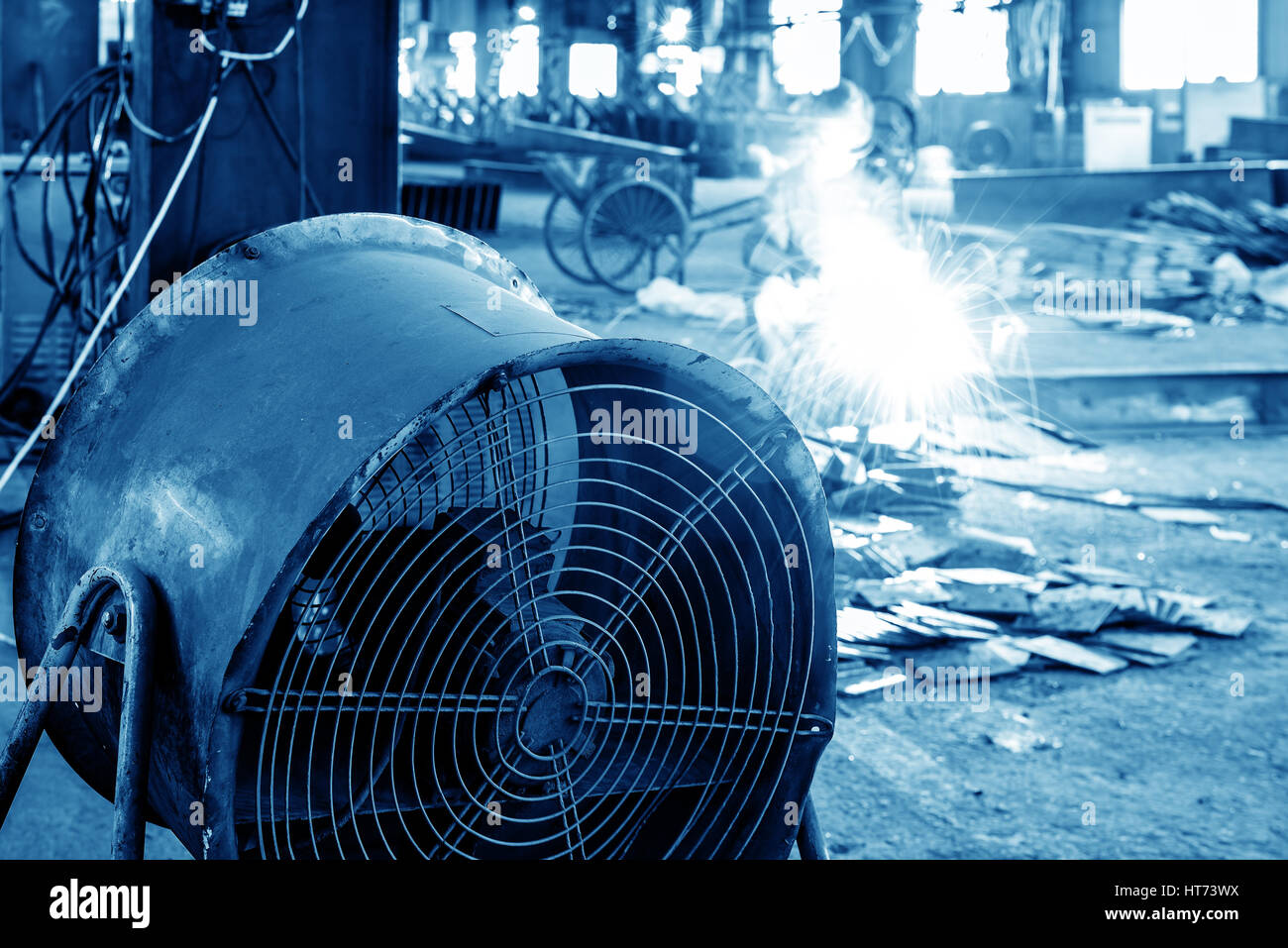 In the factory floor, the workers are burning the welding operation Stock Photo