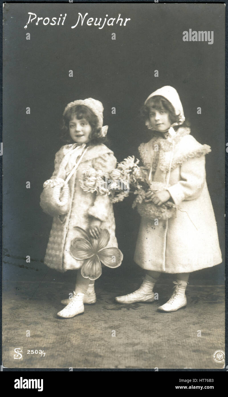 GERMANY - CIRCA 1907: A postcard printed in Germany, shows two little girls. The inscription in German: Happy New Year, circa 1907 Stock Photo