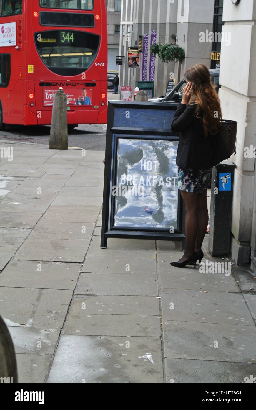 woman using phone next to A-Frame advertising Hot Breakfast, London Stock Photo
